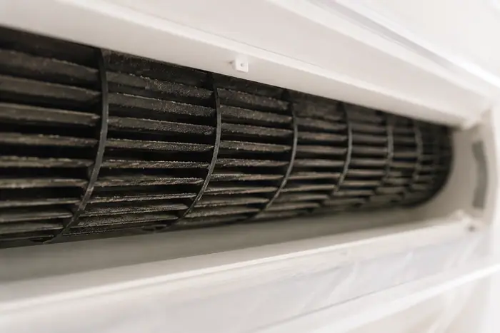 Curatare sub husa: prim-plan al ventilatorului AC prafuit